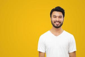 hombre guapo asiático con bigote, sonriendo y riendo aislado de fondo amarillo foto