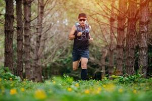 A man Runner of Trail and athlete's feet wearing sports shoes for trail running in the forest photo