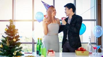 Asian Couple lover having party with alcoholic beer drinks and Young people enjoying at a bar toasting cocktails with Christmas gift in Christmas holiday and happy new year patty photo