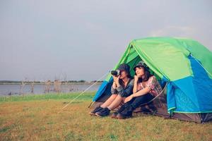 un grupo de amigos asiáticos turistas toman fotos juntos con felicidad en verano mientras acampan