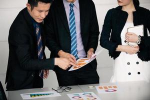 businessmen working and point on graph financial diagram and analysis documents on office table photo