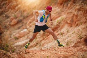 A man Runner of Trail . and athlete's feet wearing sports shoes for trail running in the mountains photo