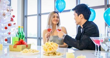 pareja asiática amante de la fiesta con bebidas alcohólicas de cerveza y jóvenes disfrutando en un bar brindando cócteles con regalo de navidad en vacaciones de navidad y feliz patty de año nuevo foto