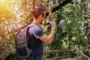 Asian men backpacks and traveler walking together and happy are taking photo on mountain  ,Relax time on holiday concept travel