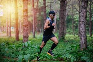 un hombre corredor de senderos y pies de atleta usando zapatos deportivos para correr en el bosque