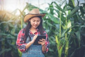 mujeres agrónomas y agricultoras de asia que utilizan tecnología para inspeccionar el campo de maíz agrícola foto