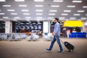 viajero asiático con maletas caminando y transporte en un aeropuerto foto