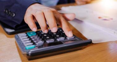 Businessmen are using calculators and analysis business data and and graph financial diagram working  at the meeting. photo