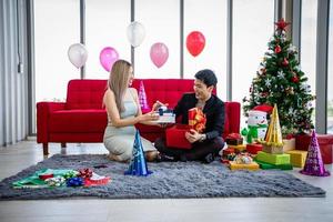 Asian couple lover are giving a gift box with Christmas gift in Christmas holiday and happy new year patty photo