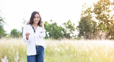 las mujeres asiáticas sonríen felizmente en el tiempo de relajación en el prado y la hierba foto