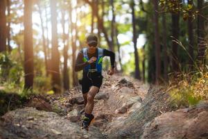 A man Runner of Trail . and athlete's feet wearing sports shoes for trail running in the forest photo