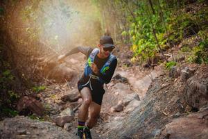 A man Runner of Trail . and athlete's feet wearing sports shoes for trail running in the forest photo