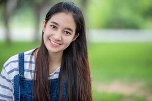 Smiling beautiful Asian girl at tree on park in summer for relax time photo