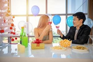 Asian Couple lover having party with alcoholic beer drinks and Young people enjoying at a bar toasting cocktails with Christmas gift in Christmas holiday and happy new year patty photo