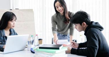 Los estudiantes del grupo sonríen y se divierten y el uso de la tableta también ayuda a compartir ideas en el trabajo y el proyecto. y también revisar el libro antes del examen foto