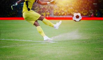 fútbol o jugador de fútbol de pie con la pelota en el campo para patear la pelota de fútbol en el estadio de fútbol foto