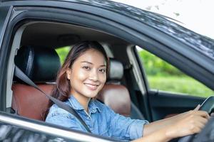 Beautiful Asian woman smiling and enjoying.driving a car on road for travel photo