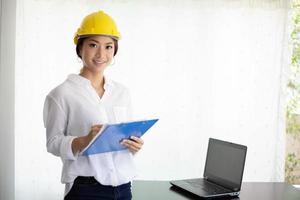 Asian women engineering inspecting and working and holding blueprints at office photo