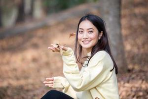 Hermosa mujer asiática sonriente niña feliz y vistiendo ropa abrigada retrato de invierno y otoño al aire libre en el parque foto