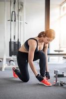 mujeres asiáticas atar cordones de zapatos. mujeres fitness preparándose para participar en el gimnasio foto