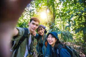 Asian Group of young people with friends and backpacks walking together and happy friends are taking photo and selfie ,Relax time on holiday concept travel