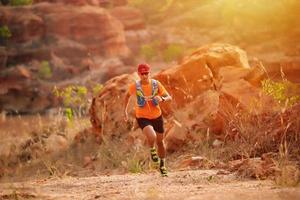 A man Runner of Trail and athlete's feet wearing sports shoes for trail running in the forest photo