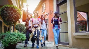 Grupo asiático de jóvenes con mochilas de amigos caminando juntos y amigos felices están tomando fotos y autofotos, tiempo de relax en viajes de concepto de vacaciones