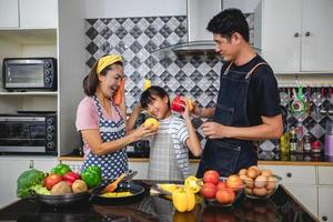 Happy Family have Dad, Mom and their little daughter Cooking Together in the Kitchen photo