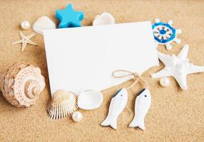 conchas, estrellas de mar y una postal en blanco foto
