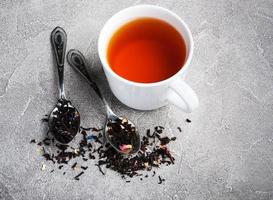 Tea cup and assortment of dry tea in spoons photo