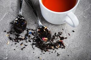 Tea cup and assortment of dry tea in spoons photo