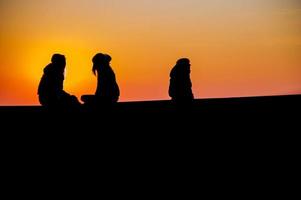 Confidences between two teenagers at sunset. photo