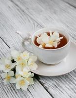 Cup of tea with jasmine flowers photo