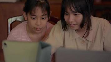dos hermanas usando tableta digital juntas en casa. video