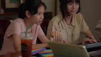 dos adolescentes jugando videojuegos en línea en un dispositivo digital en casa.