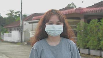 Portrait young woman wearing protective face mask and looking at camera. video