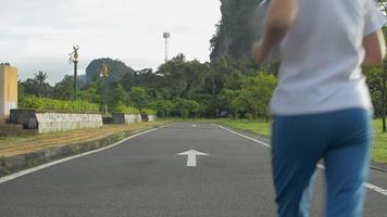 donna che fa jogging sul sentiero nel parco pubblico. video