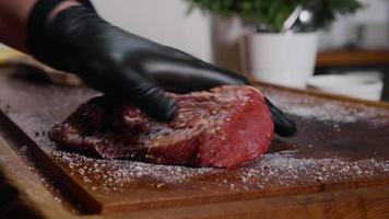 viande de boeuf au sel et poivre sur hachoir à bois. video