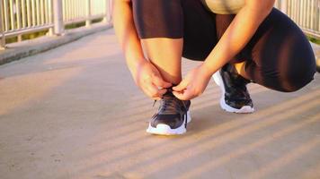 woman tying shoelaces on a footbridge video