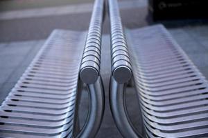 Close up of contemporary modern stainless steel street or park bench. Selective Focus. photo