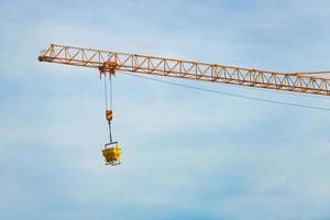 A tower crane in action in the sky of a building site photo