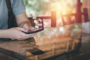 Social media with smartphone concept. Hand holding black mobile phone with white icon of applications, internet marketing, e-learning, and shopping online. photo