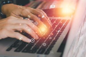 Hi-tech of business and financial concept. Hand typing keyboard of laptop with virtual business icon. Digital business and social media interface. Innovation searching, mail, artificial intelligence. photo