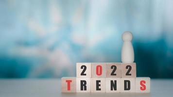 2022 trends concept. Wooden cube block with text 2022 trends and wooden figure. New idea, fashion, popular topic. Business opportunity.