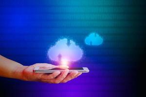 Hand holding smartphone with cloud icon on blue and green binary code background. Communication of business and financial. Cloud data storage concept. photo