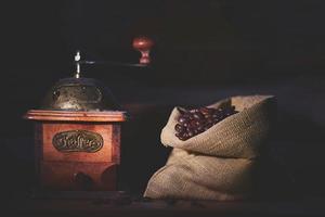 Coffee grinder with a jute bag full of beans photo