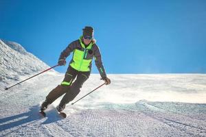 Skier practicing alpine skiing on the slope of a ski area photo