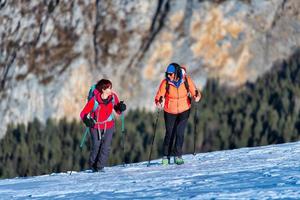 par de mujeres amistosas durante una caminata de montaña en la nieve foto