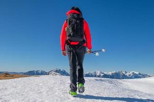 trekking de una chica solitaria en la nieve foto