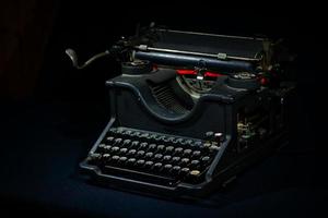 Ancient  typewriter on a black background photo